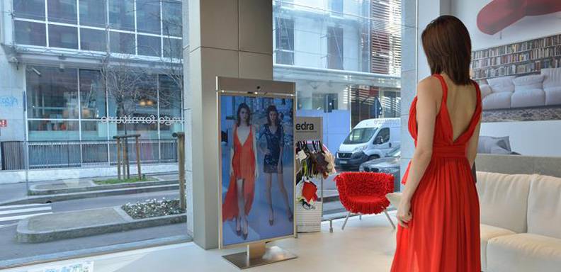 Una mujer observando un vestido en el Memory Mirror, la empresa que desarrolló Memomi