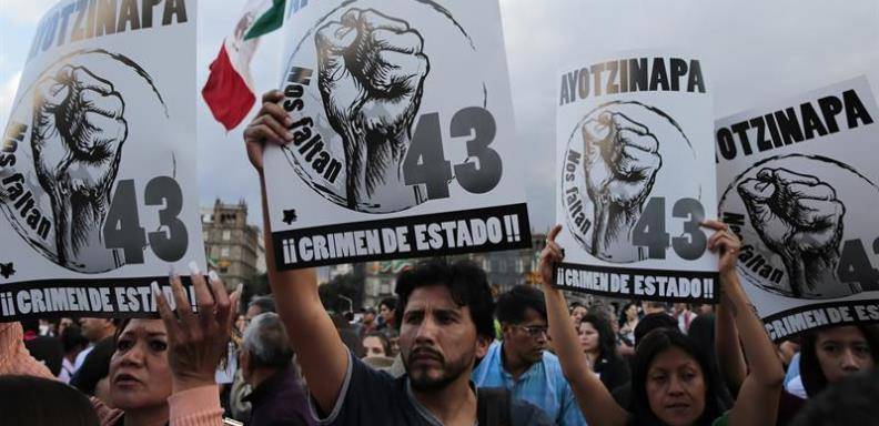 Un grupo de personas, que apoyan a los familiares de los normalistas desaparecidos en Iguala, México protestan en la marcha. /Foto EFE