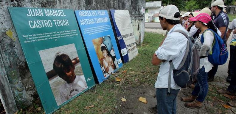 Visitantes observan el 5 de noviembre de 2015 fotografías de niños desaparecidos hace treinta años durante un alud, en Armero (Colombia).